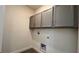 Laundry room with gray cabinets and vinyl flooring at 9141 Gulf Haven Dr, Parrish, FL 34219