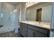 Bathroom with double vanity, gray cabinets and a walk-in shower at 9141 Gulf Haven Dr, Parrish, FL 34219