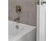 White bathtub with gray tile surround and brushed nickel fixtures at 9136 Gulf Haven Dr, Parrish, FL 34219
