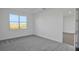 Well-lit bedroom featuring gray carpet and access to another room at 9136 Gulf Haven Dr, Parrish, FL 34219