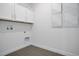 Bright laundry room with white cabinets and gray tile floor at 9136 Gulf Haven Dr, Parrish, FL 34219