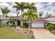 Single-story home with a brown roof, white garage door, and palm trees at 254 Rotonda E Blvd, Rotonda West, FL 33947