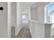 Hallway with view to rooms with windows, showcasing light walls and gray carpet at 9043 Duany Ln, Lakewood Ranch, FL 34240