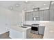 Modern kitchen features gray cabinets, white countertops, and stainless appliances at 9043 Duany Ln, Lakewood Ranch, FL 34240