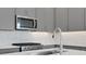 Close up of kitchen features a stainless steel sink, stove, and microwave at 9043 Duany Ln, Lakewood Ranch, FL 34240