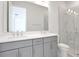 Modern main bathroom with double sinks, marble-look shower and sleek vanity offers luxury and functionality at 9043 Duany Ln, Lakewood Ranch, FL 34240