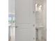 A charming powder room features a pedestal sink and modern lighting with a view of the kitchen at 9043 Duany Ln, Lakewood Ranch, FL 34240