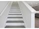 Stylish staircase with wood treads and white risers connects multiple levels of the home with an elegant design at 9043 Duany Ln, Lakewood Ranch, FL 34240
