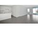 Open living area with grey tile floors, white kitchen, and access to patio at 9144 Gulf Haven Dr, Parrish, FL 34219