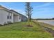 Home's backyard with covered patio, grassy area, and pond view at 7474 Sea Manatee St, Parrish, FL 34219