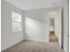 Well-lit bedroom with neutral walls, carpet, and an adjacent hallway at 7474 Sea Manatee St, Parrish, FL 34219