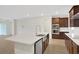 Kitchen features an island with a stainless steel sink and dark wood cabinets at 7474 Sea Manatee St, Parrish, FL 34219