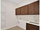 Bright laundry room with upper cabinets and utility sink at 7474 Sea Manatee St, Parrish, FL 34219
