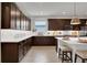 Modern kitchen with dark wood cabinets, white countertops, and stainless steel appliances at 7465 Sea Manatee St, Parrish, FL 34219