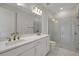 Bathroom with double sink vanity, granite countertop, frameless shower and tile flooring at 9031 Duany Ln, Lakewood Ranch, FL 34240