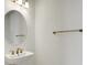Bathroom with white sink and round mirror, with brass faucet and accents at 9031 Duany Ln, Lakewood Ranch, FL 34240