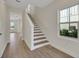 Foyer with staircase, light hardwood floors, window and view to front door at 9031 Duany Ln, Lakewood Ranch, FL 34240