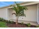 Stylish home entrance with verdant landscaping and a beautiful ornamental palm tree at 9031 Duany Ln, Lakewood Ranch, FL 34240