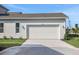 Attached two-car garage with exterior lighting, driveway, and manicured landscaping at 9031 Duany Ln, Lakewood Ranch, FL 34240