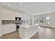 Bright, open kitchen with stainless steel appliances, white cabinets, and large island at 9031 Duany Ln, Lakewood Ranch, FL 34240