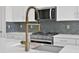 Modern kitchen features stainless steel appliances, brass faucet, and white cabinets at 9031 Duany Ln, Lakewood Ranch, FL 34240
