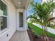 Side entrance featuring a palm tree, grass, mulch, and a concrete walkway at 9031 Duany Ln, Lakewood Ranch, FL 34240