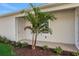 Side entrance featuring a palm tree, grass, mulch, and a concrete walkway at 9031 Duany Ln, Lakewood Ranch, FL 34240
