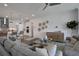 Open living space with gray sofas, a large glass coffee table, and a view of the kitchen at 7458 Sea Manatee St, Parrish, FL 34219