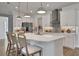 Modern kitchen with white cabinets, quartz countertops and an island with seating at 7458 Sea Manatee St, Parrish, FL 34219