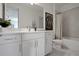 Modern bathroom with white cabinets, a large mirror, and a bathtub at 7458 Sea Manatee St, Parrish, FL 34219