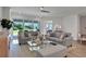 Spacious living room showcasing gray sofas, a glass coffee table, and access to a patio at 7458 Sea Manatee St, Parrish, FL 34219