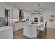 Island kitchen with white cabinets, quartz countertops, and modern pendant lighting at 7458 Sea Manatee St, Parrish, FL 34219