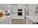 Modern kitchen with white cabinets, built-in oven, and walk-in pantry at 7458 Sea Manatee St, Parrish, FL 34219