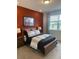 Cozy bedroom with a burnt orange accent wall and large window at 9230 Gulf Haven Dr, Parrish, FL 34219