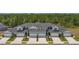 Front view of townhouses with gray siding, white garage doors, and landscaping at 9230 Gulf Haven Dr, Parrish, FL 34219