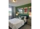 Bright bedroom with a double bed, green accent wall, and tennis-themed artwork at 9246 Gulf Haven Dr, Parrish, FL 34219