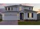 Two-story house with gray siding, dark gray door, and a three-car garage at 7454 Sea Manatee St, Parrish, FL 34219