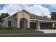 One-story house with arched entryway, dark gray garage doors, and landscaping at 7442 Sea Manatee St, Parrish, FL 34219