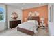 Spacious bedroom with a modern dresser, an accent wall and warm lighting at 7438 Sea Manatee St, Parrish, FL 34219