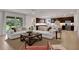 Open living room with sectional sofa, large windows, and view of backyard at 7434 Sea Manatee St, Parrish, FL 34219