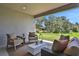 Relaxing covered patio with seating area, offering a view of the backyard at 7434 Sea Manatee St, Parrish, FL 34219