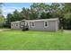 Gray manufactured home with green lawn at 10215 Poplar St, New Port Richey, FL 34654