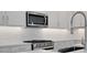 Close-up of modern kitchen with stainless steel appliances, white subway tile backsplash, and designer faucet at 176 Eagleston Ln, Lakewood Ranch, FL 34240