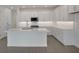 Bright and airy kitchen featuring an island, white cabinetry, stainless steel appliances, and modern finishes at 176 Eagleston Ln, Lakewood Ranch, FL 34240