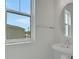 Bathroom featuring a pedestal sink with chrome fixtures and a modern round mirror at 180 Eagleston Ln, Lakewood Ranch, FL 34240