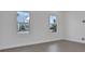 Neutral bedroom with tile floors and two windows offering a view of the neighborhood at 180 Eagleston Ln, Lakewood Ranch, FL 34240
