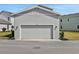 Spacious two-car garage with a neutral-colored door and exterior lighting at 180 Eagleston Ln, Lakewood Ranch, FL 34240