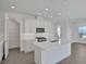 Bright, open kitchen with stainless appliances, center island, and wood-look tile floors at 180 Eagleston Ln, Lakewood Ranch, FL 34240