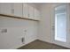 Laundry room featuring white cabinets, tile flooring, and access to the outside at 180 Eagleston Ln, Lakewood Ranch, FL 34240