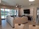 Bright living room featuring a sectional sofa and sliding glass doors leading to the pool at 5013 Sevilla Shores Dr, Wimauma, FL 33598